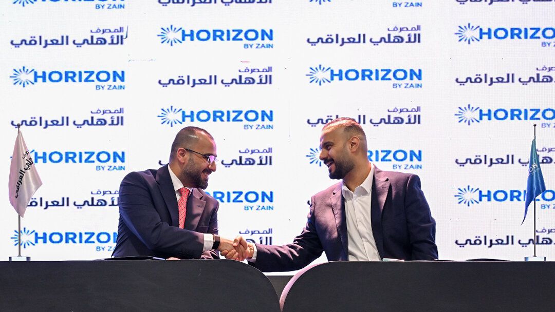 Horizon and National Bank of Iraq representatives shaking hands after signing the agreement at ITEX Iraq 2026